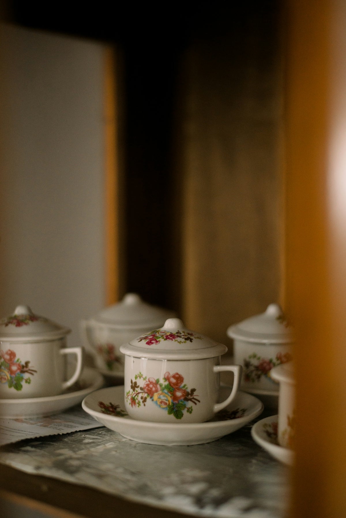 Several teacups with floral patterns on saucers.