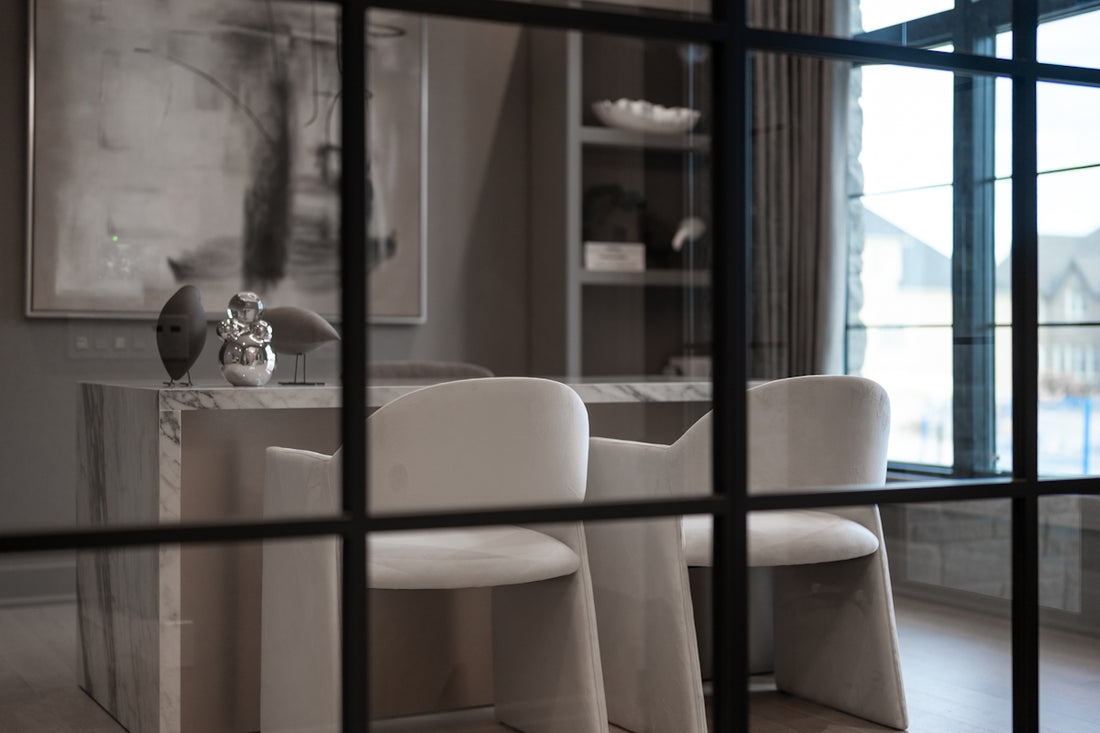 Elegant office interior with white chairs behind a grid window.