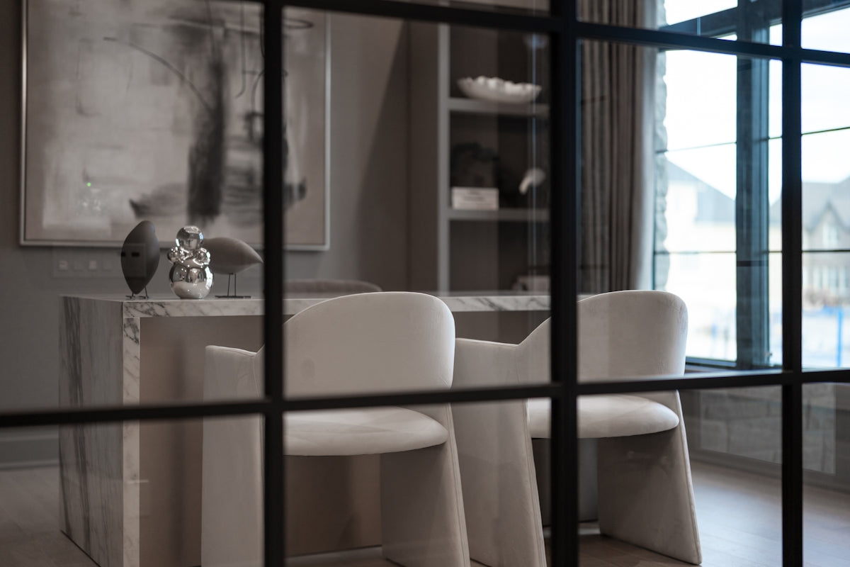 Elegant office interior with white chairs behind a grid window.